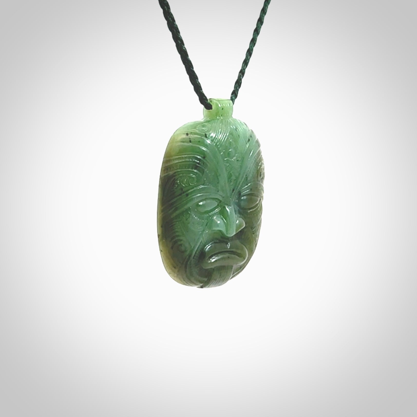 This picture shows a hand carved Jade face pendant. It is a varied green colour which is quite beautiful. Although a medium piece, it is a wonderful, delicate piece of jewellery. The cord is hand plaited and adjustable so that you can position the pendant where it suits you best. Delivery is free worldwide.