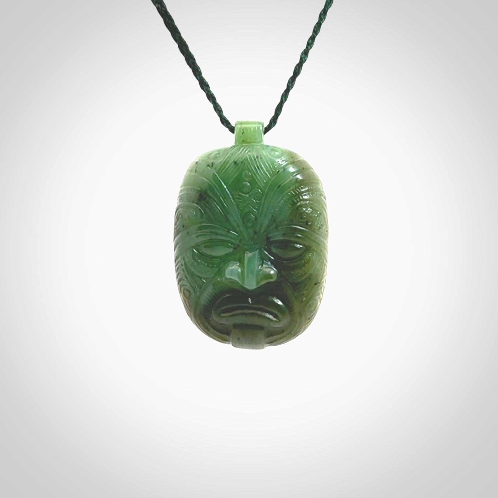 This picture shows a hand carved Jade face pendant. It is a varied green colour which is quite beautiful. Although a medium piece, it is a wonderful, delicate piece of jewellery. The cord is hand plaited and adjustable so that you can position the pendant where it suits you best. Delivery is free worldwide.