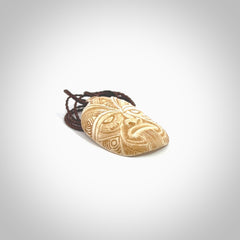 This picture shows a hand carved face pendant. It is carved from bone and although a medium piece, it is a wonderful, delicate piece of jewellery. The cord is hand plaited and adjustable so that you can position the pendant where it suits you best. Delivery is free worldwide.