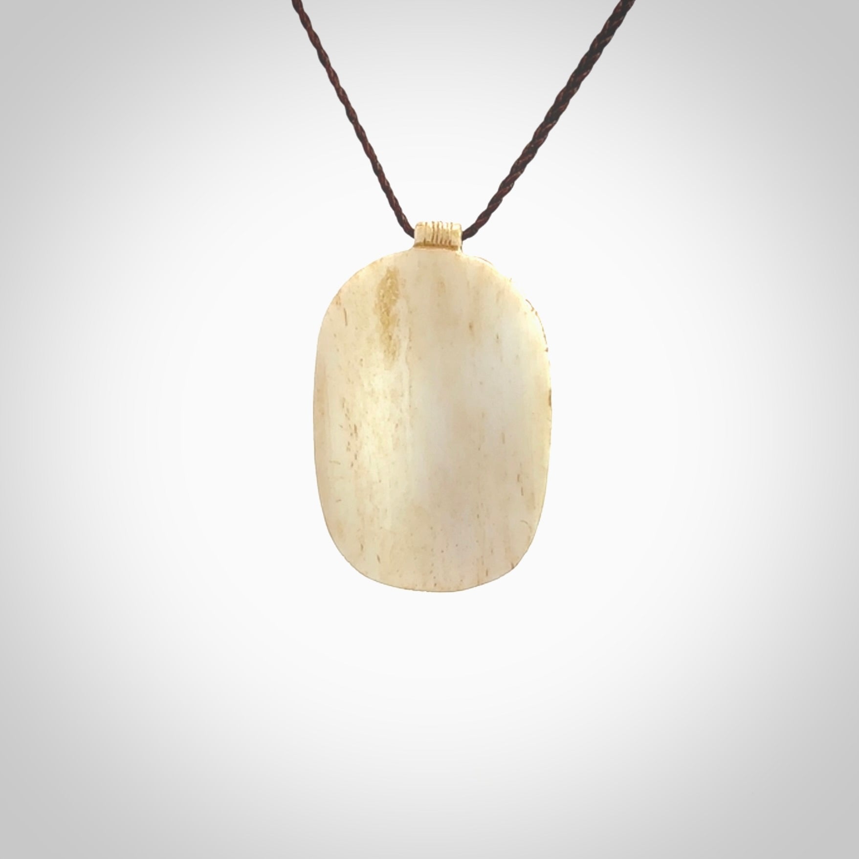 This picture shows a hand carved face pendant. It is carved from bone and although a medium piece, it is a wonderful, delicate piece of jewellery. The cord is hand plaited and adjustable so that you can position the pendant where it suits you best. Delivery is free worldwide.