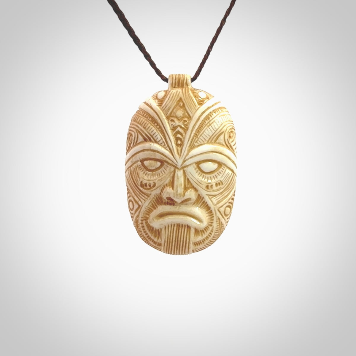 This picture shows a hand carved face pendant. It is carved from bone and although a medium piece, it is a wonderful, delicate piece of jewellery. The cord is hand plaited and adjustable so that you can position the pendant where it suits you best. Delivery is free worldwide.