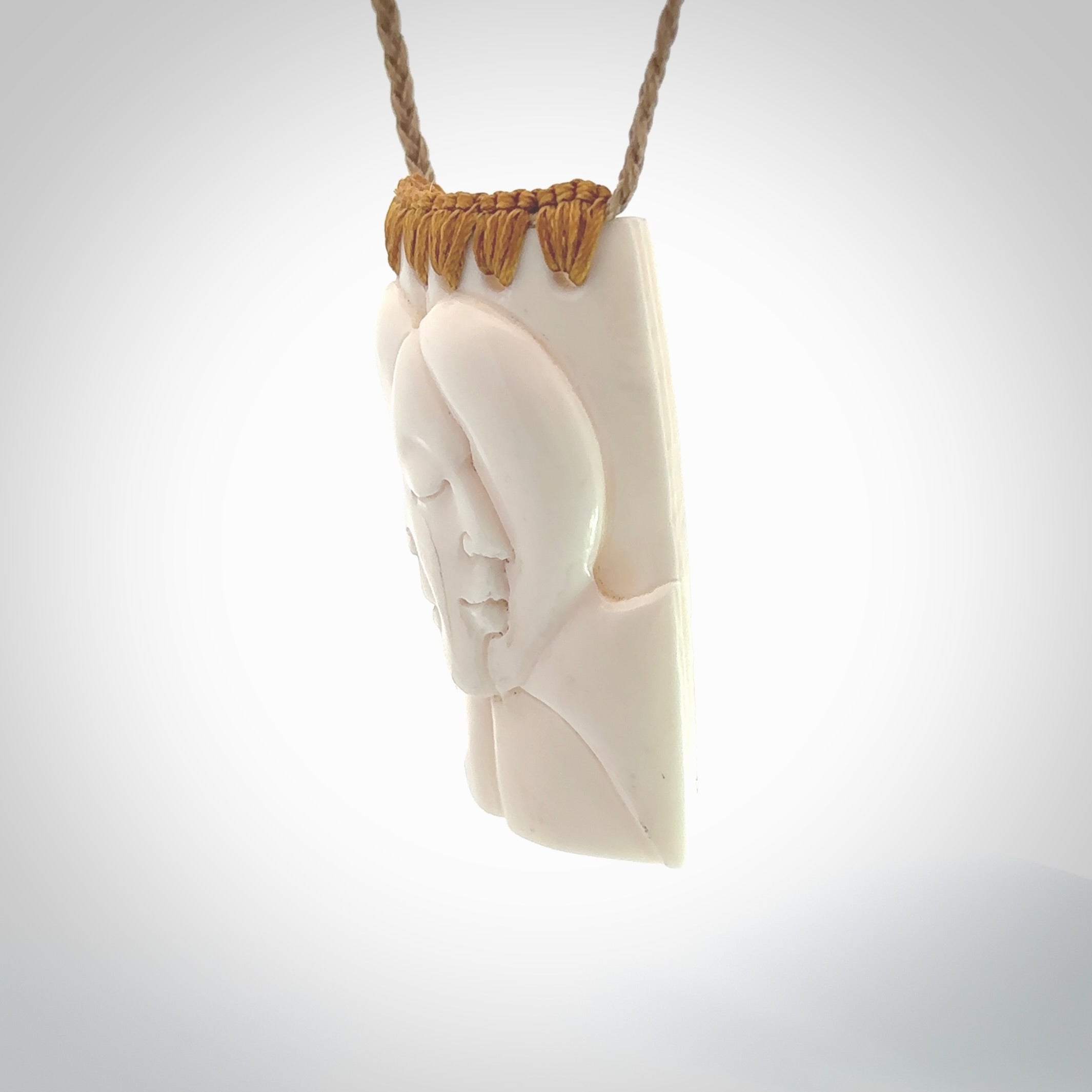 Hand carved large bone drop with double face carving. A stunning work of art. This pendant is hand carved in bone and provided with an adjustable cord. A one off work of art to wear by NZ Pacific.