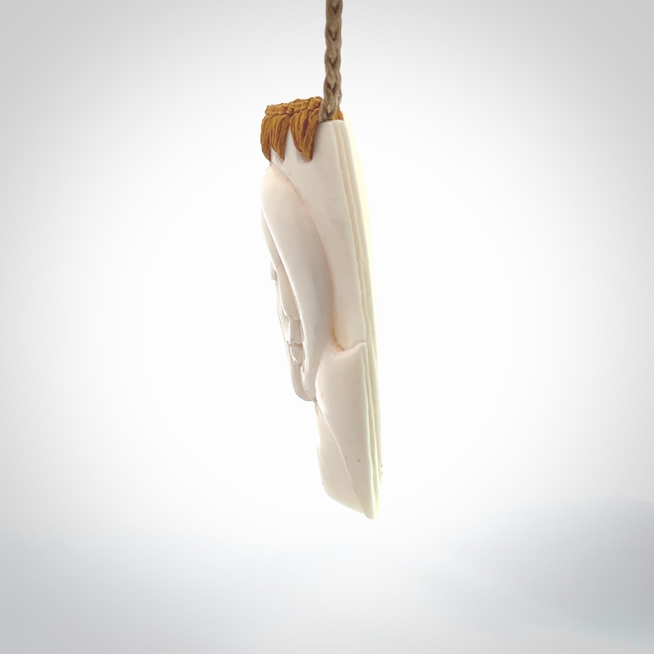 Hand carved large bone drop with double face carving. A stunning work of art. This pendant is hand carved in bone and provided with an adjustable cord. A one off work of art to wear by NZ Pacific.