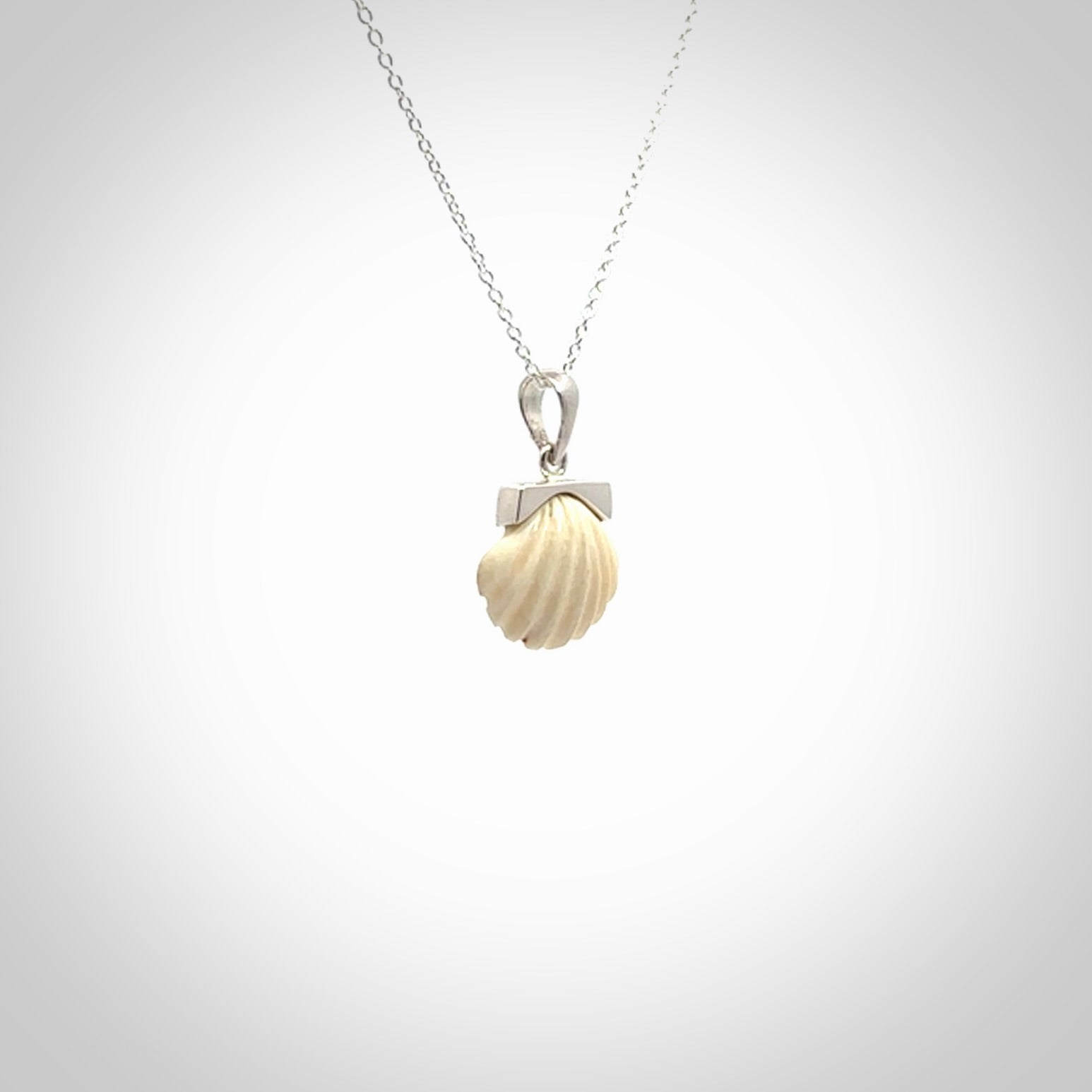 Hand made woolly mammoth tusk fanshell necklace with Sterling Silver. Mammoth tusk fanshell pendant with Sterling silver surround and chain. Made by NZ Pacific and sale online only.