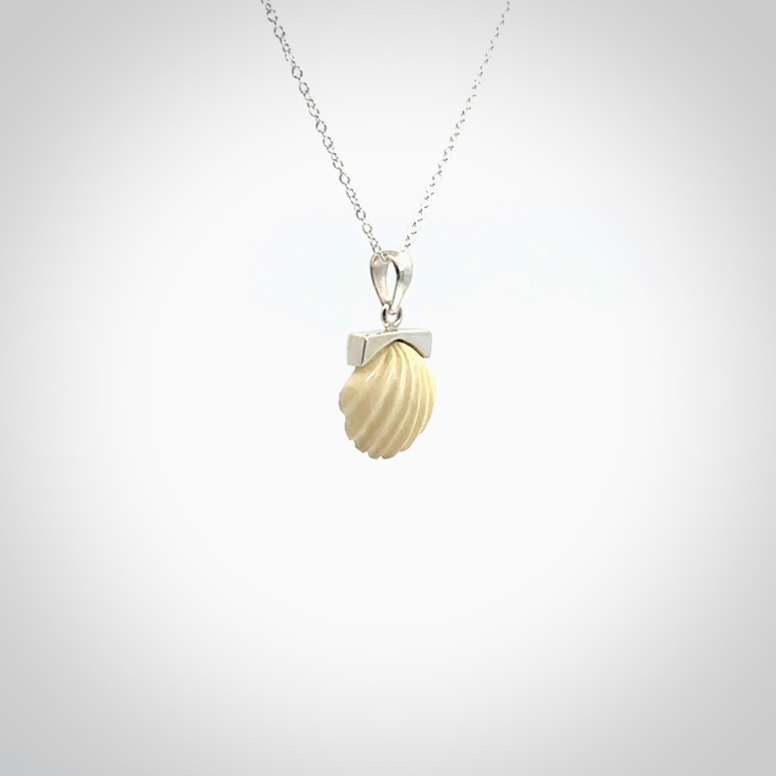 Hand made woolly mammoth tusk fanshell necklace with Sterling Silver. Mammoth tusk fanshell pendant with Sterling silver surround and chain. Made by NZ Pacific and sale online only.