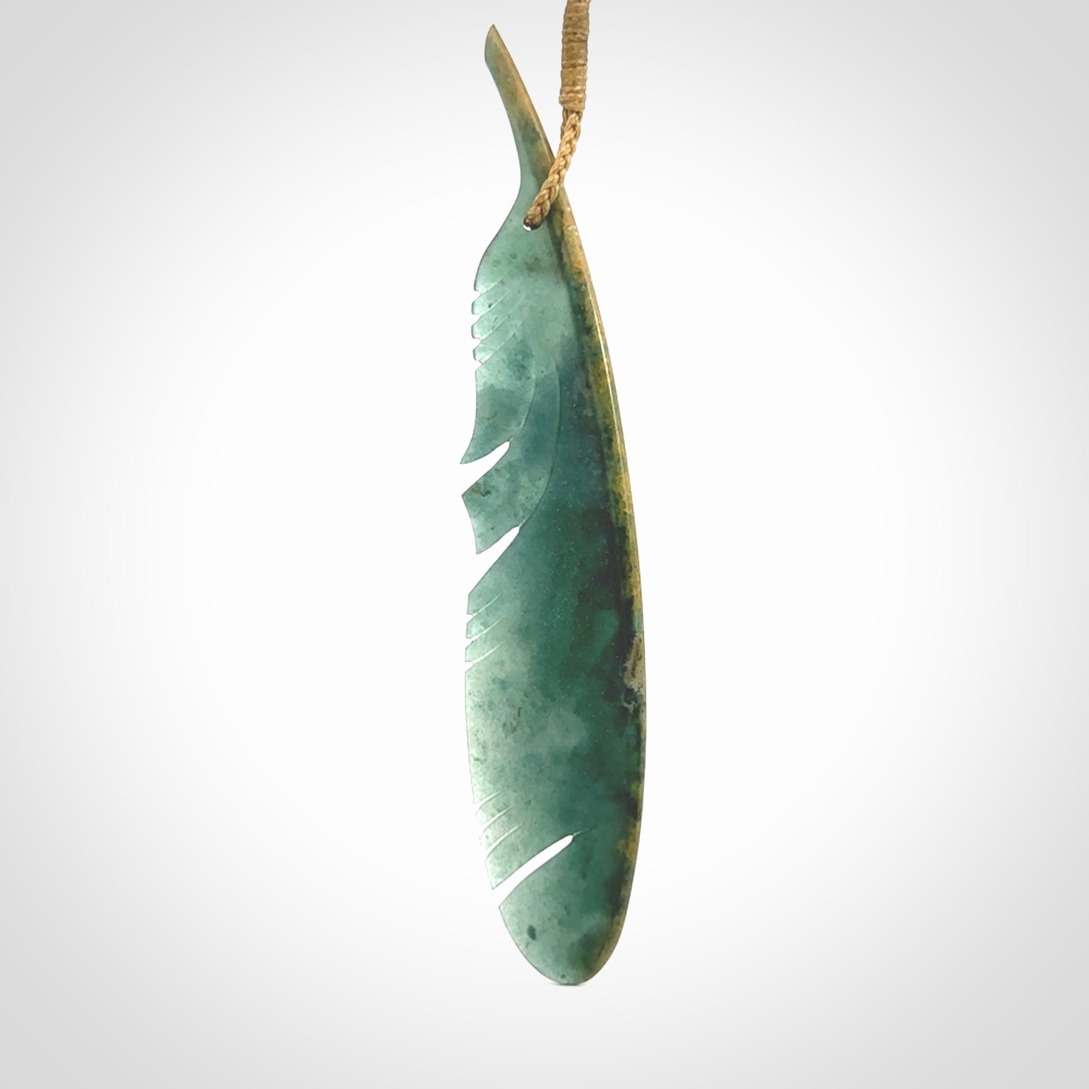 A hand carved large New Zealand Flower Jade Haast Eagle feather necklace. The cord is a tan colour and is a fixed length. A large sized hand made Jade Haast eagle feather pendant by New Zealand artist Kerry Thompson. One off work of art to wear.