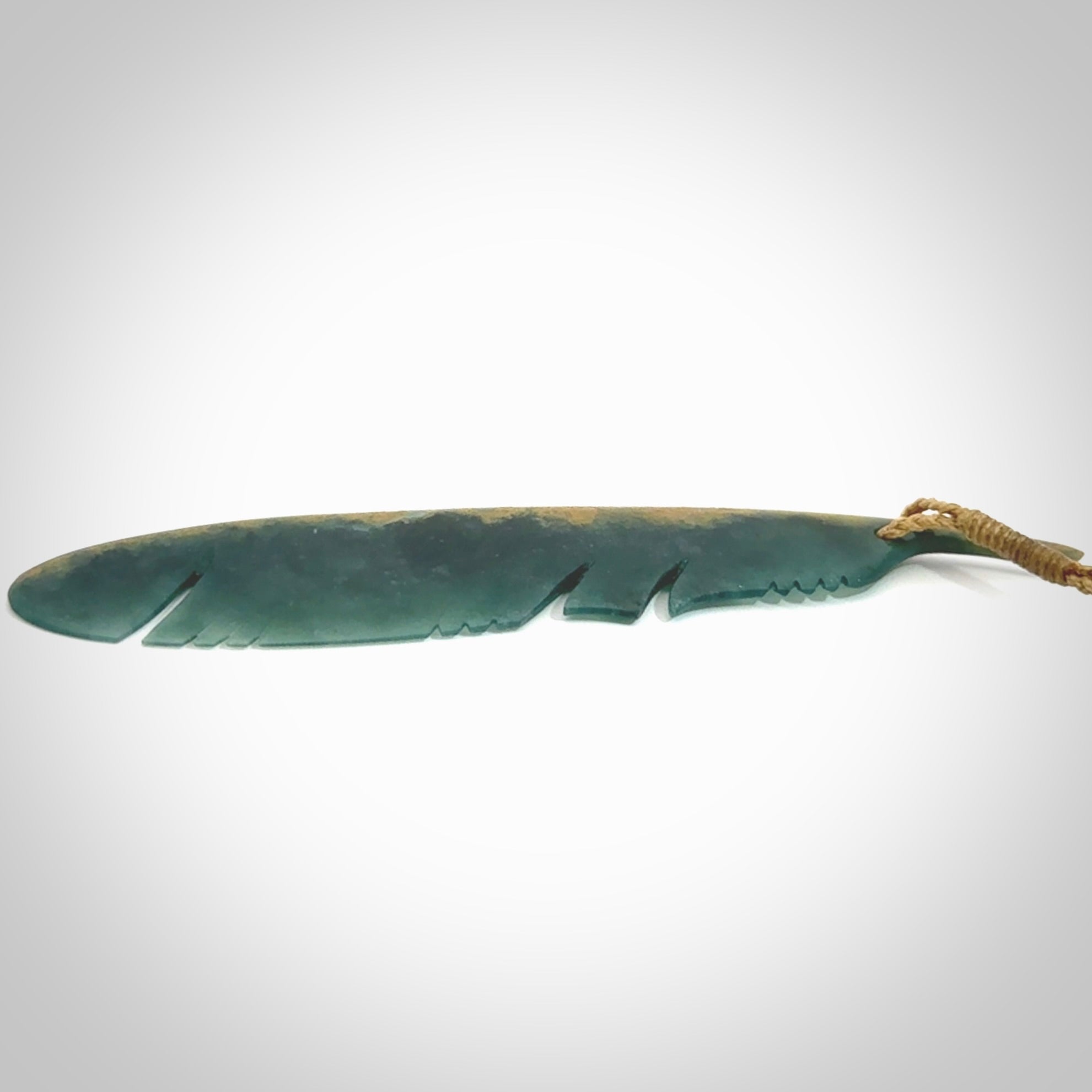 A hand carved large New Zealand Flower Jade Haast Eagle feather necklace. The cord is a tan colour and is a fixed length. A large sized hand made Jade Haast eagle feather pendant by New Zealand artist Kerry Thompson. One off work of art to wear.