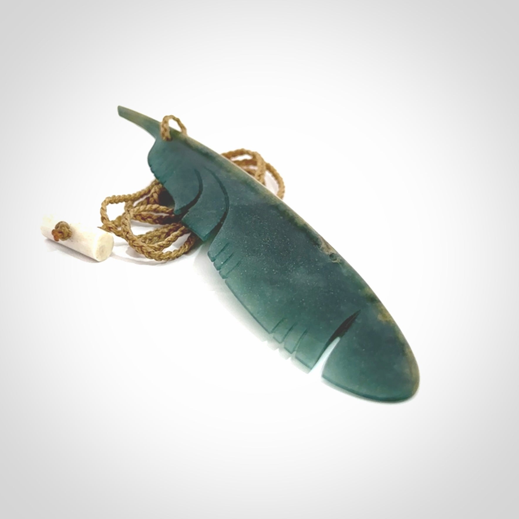 A hand carved large New Zealand Flower Jade Haast Eagle feather necklace. The cord is a tan colour and is a fixed length. A large sized hand made Jade Haast eagle feather pendant by New Zealand artist Kerry Thompson. One off work of art to wear.