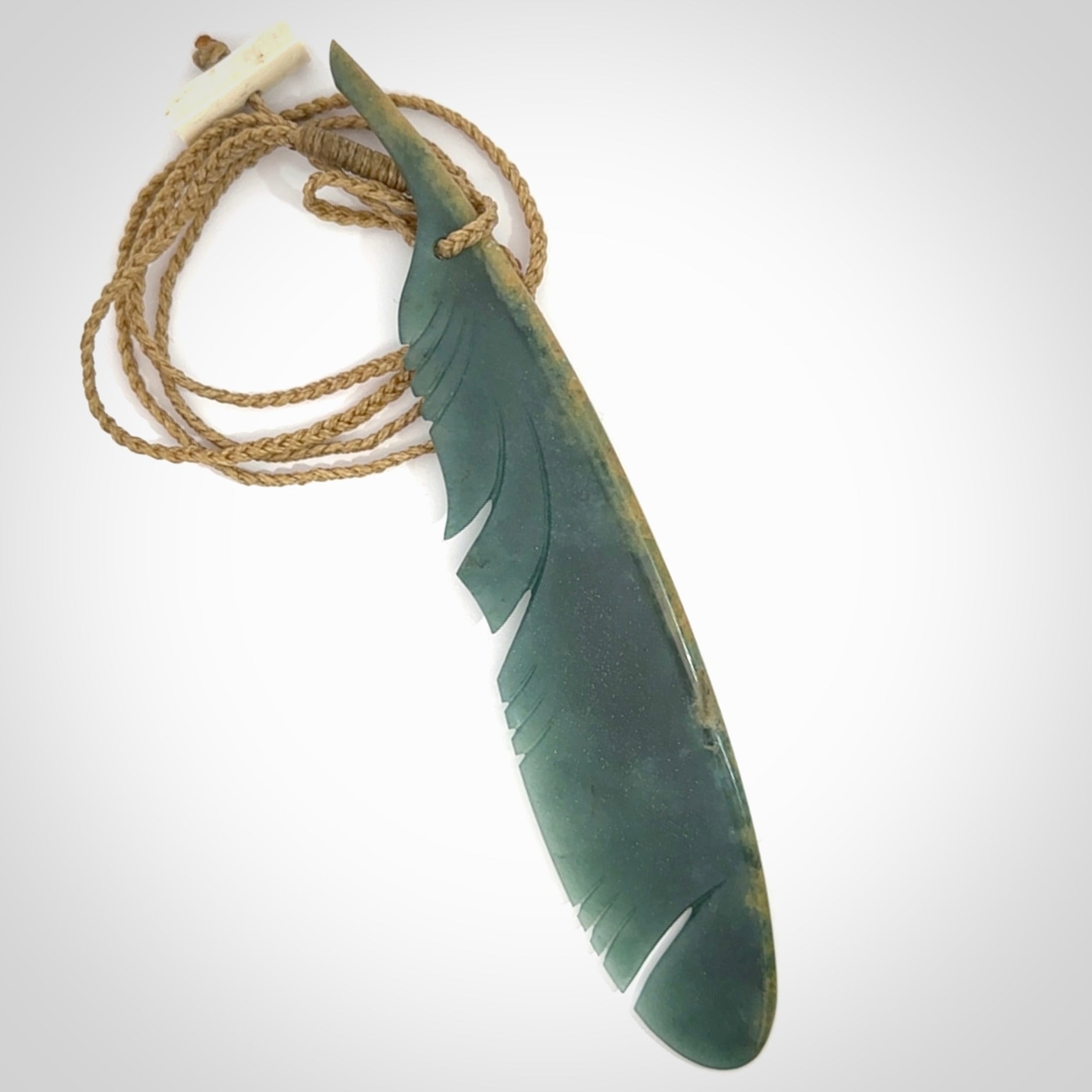 A hand carved large New Zealand Flower Jade Haast Eagle feather necklace. The cord is a tan colour and is a fixed length. A large sized hand made Jade Haast eagle feather pendant by New Zealand artist Kerry Thompson. One off work of art to wear.