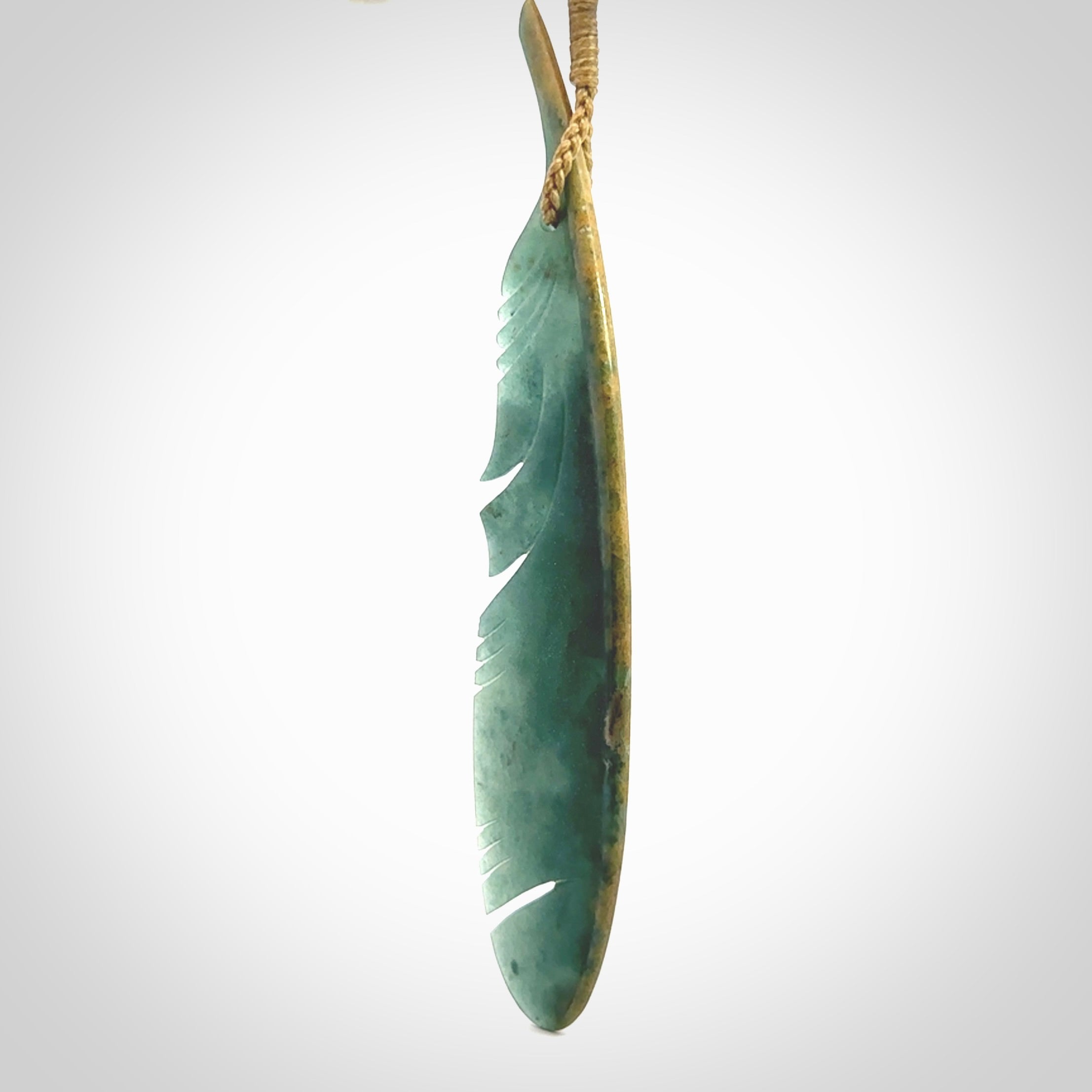 A hand carved large New Zealand Flower Jade Haast Eagle feather necklace. The cord is a tan colour and is a fixed length. A large sized hand made Jade Haast eagle feather pendant by New Zealand artist Kerry Thompson. One off work of art to wear.