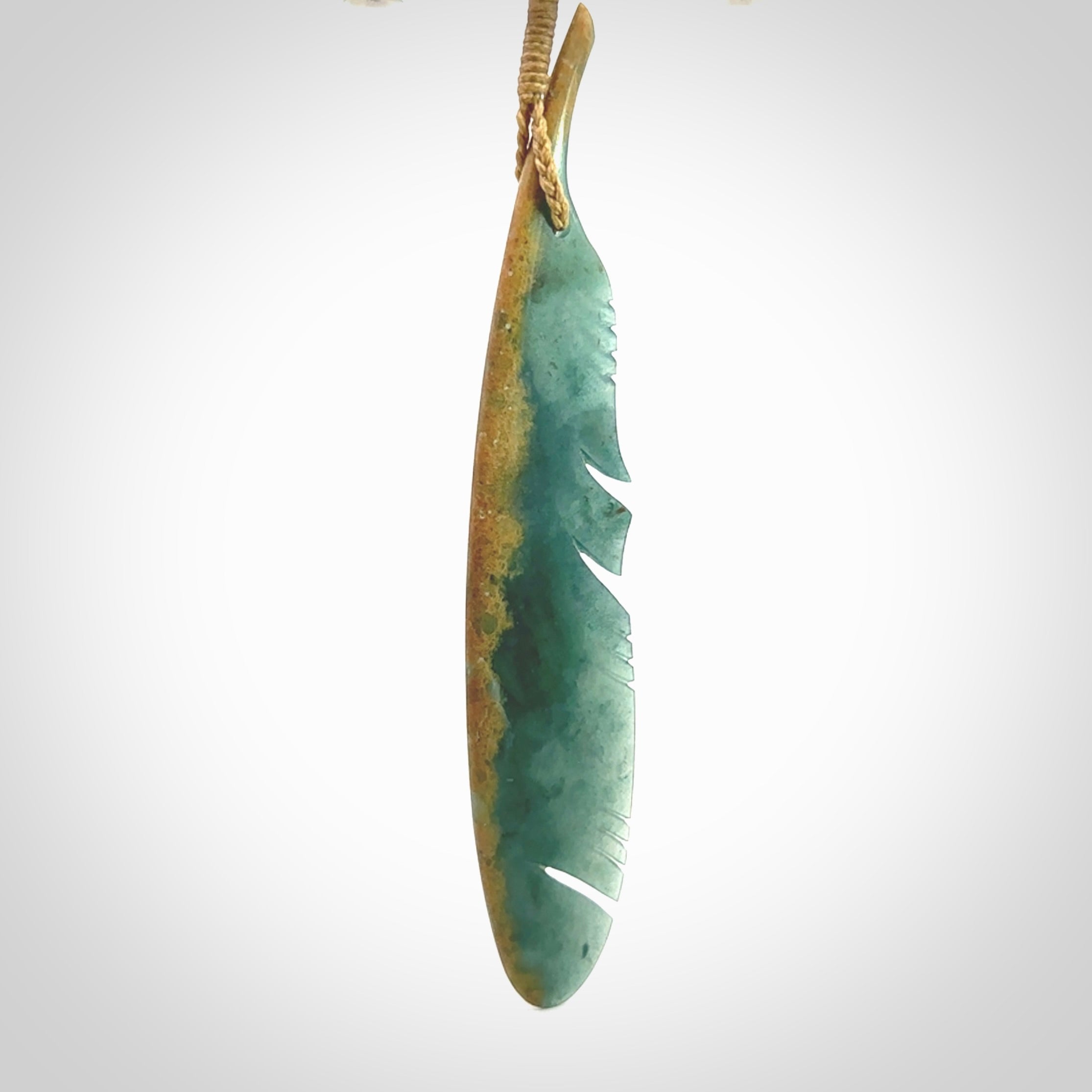 A hand carved large New Zealand Flower Jade Haast Eagle feather necklace. The cord is a tan colour and is a fixed length. A large sized hand made Jade Haast eagle feather pendant by New Zealand artist Kerry Thompson. One off work of art to wear.