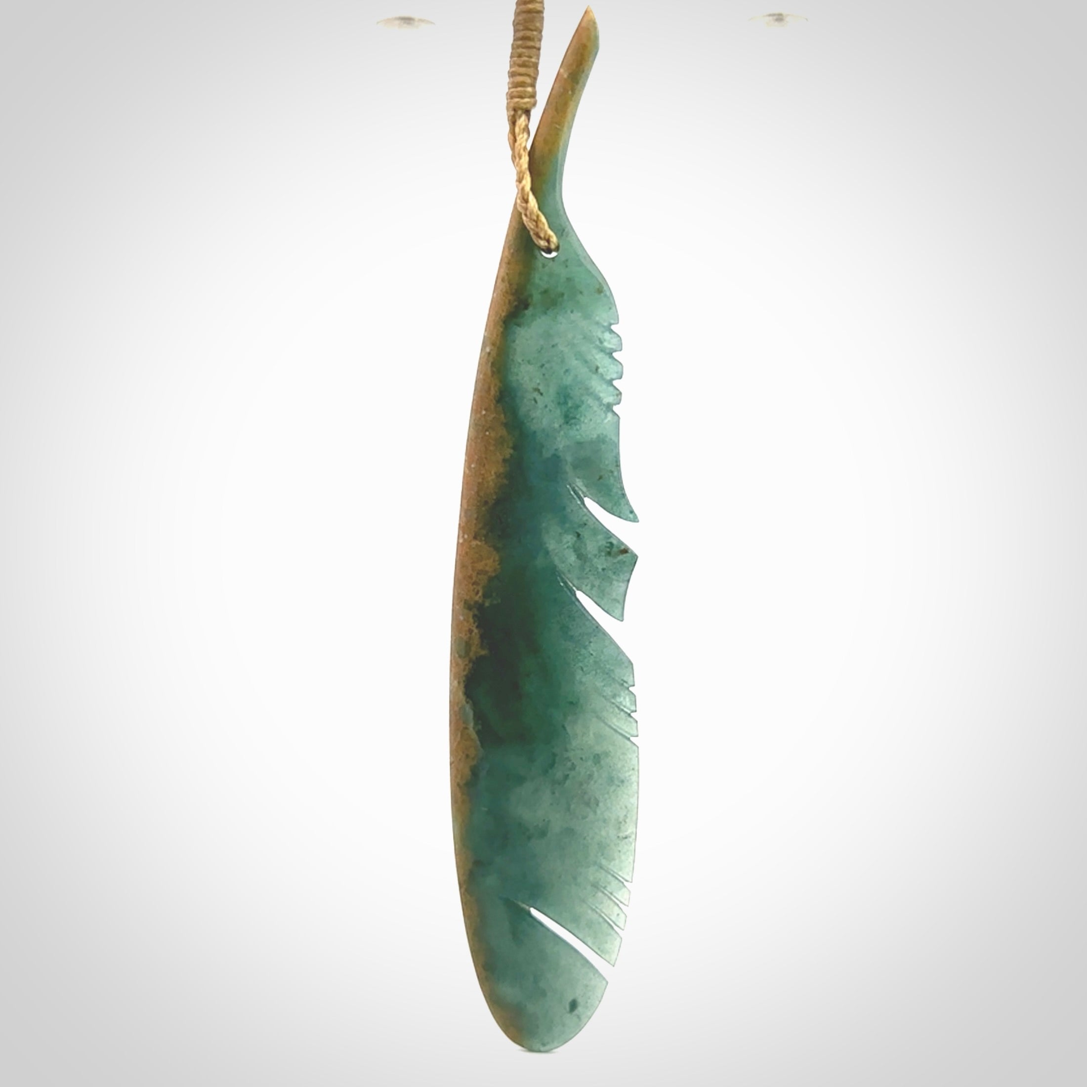 A hand carved large New Zealand Flower Jade Haast Eagle feather necklace. The cord is a tan colour and is a fixed length. A large sized hand made Jade Haast eagle feather pendant by New Zealand artist Kerry Thompson. One off work of art to wear.