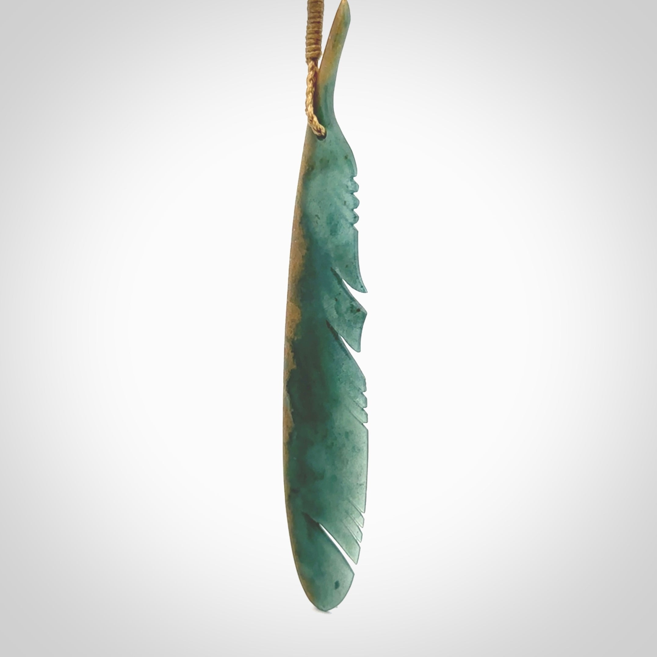 A hand carved large New Zealand Flower Jade Haast Eagle feather necklace. The cord is a tan colour and is a fixed length. A large sized hand made Jade Haast eagle feather pendant by New Zealand artist Kerry Thompson. One off work of art to wear.