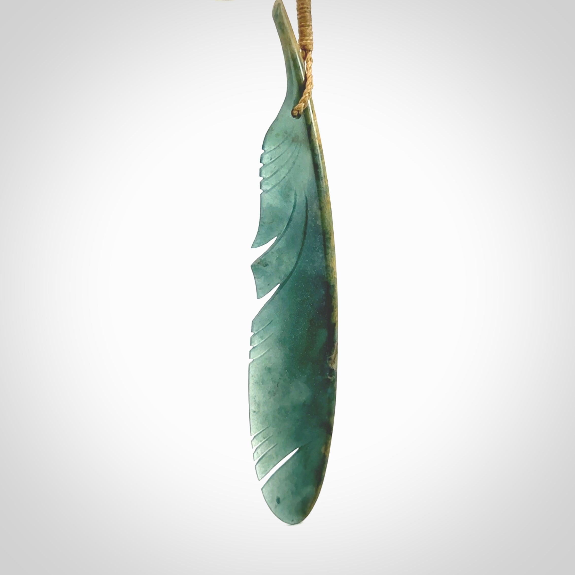 A hand carved large New Zealand Flower Jade Haast Eagle feather necklace. The cord is a tan colour and is a fixed length. A large sized hand made Jade Haast eagle feather pendant by New Zealand artist Kerry Thompson. One off work of art to wear.