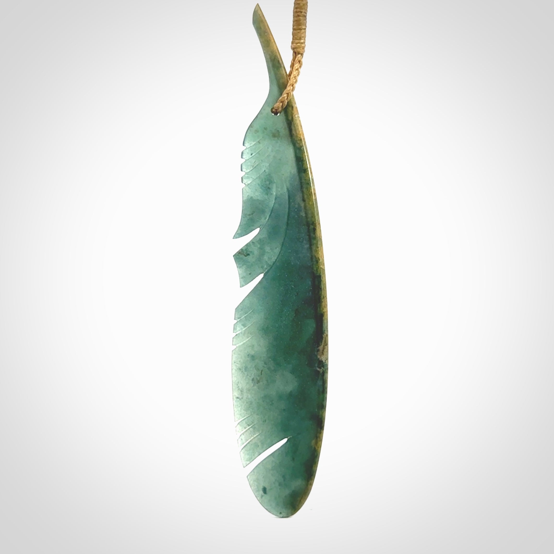 A hand carved large New Zealand Flower Jade Haast Eagle feather necklace. The cord is a tan colour and is a fixed length. A large sized hand made Jade Haast eagle feather pendant by New Zealand artist Kerry Thompson. One off work of art to wear.