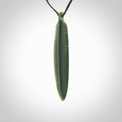 A hand carved large New Zealand Jade feather necklace. The cord is a black colour and is a fixed length. A large sized hand made Jade feather necklace by New Zealand artist Kerry Thompson. One off work of art to wear.