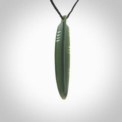 A hand carved large New Zealand Jade feather necklace. The cord is a black colour and is a fixed length. A large sized hand made Jade feather necklace by New Zealand artist Kerry Thompson. One off work of art to wear.