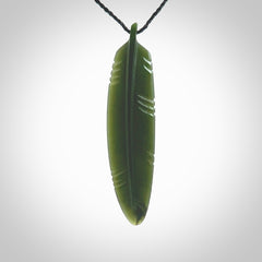 A hand carved large New Zealand Jade feather necklace. The cord is a black colour and is a fixed length. A large sized hand made Jade feather necklace by New Zealand artist Kerry Thompson. One off work of art to wear.