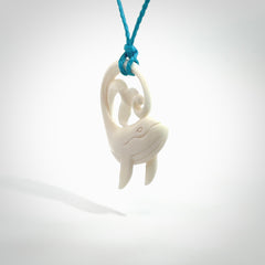 A hand carved bone whale pendant. This is a lovely piece carved to bring pleasure to the lucky wearer. It is a friendly pendant which we will ship to you free wherever you live. Carved by NZ Pacific and for sale online. Provided with an adjustable paradise blue cord.