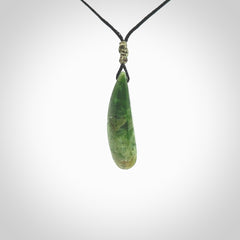 A lovely small sized New Zealand Marsden jade drop pendant. This piece is made from a deep green jade with orange specks and is a wonderful colour. Carved for NZ Pacific and delivered worldwide. Provided with an adjustable black cord.