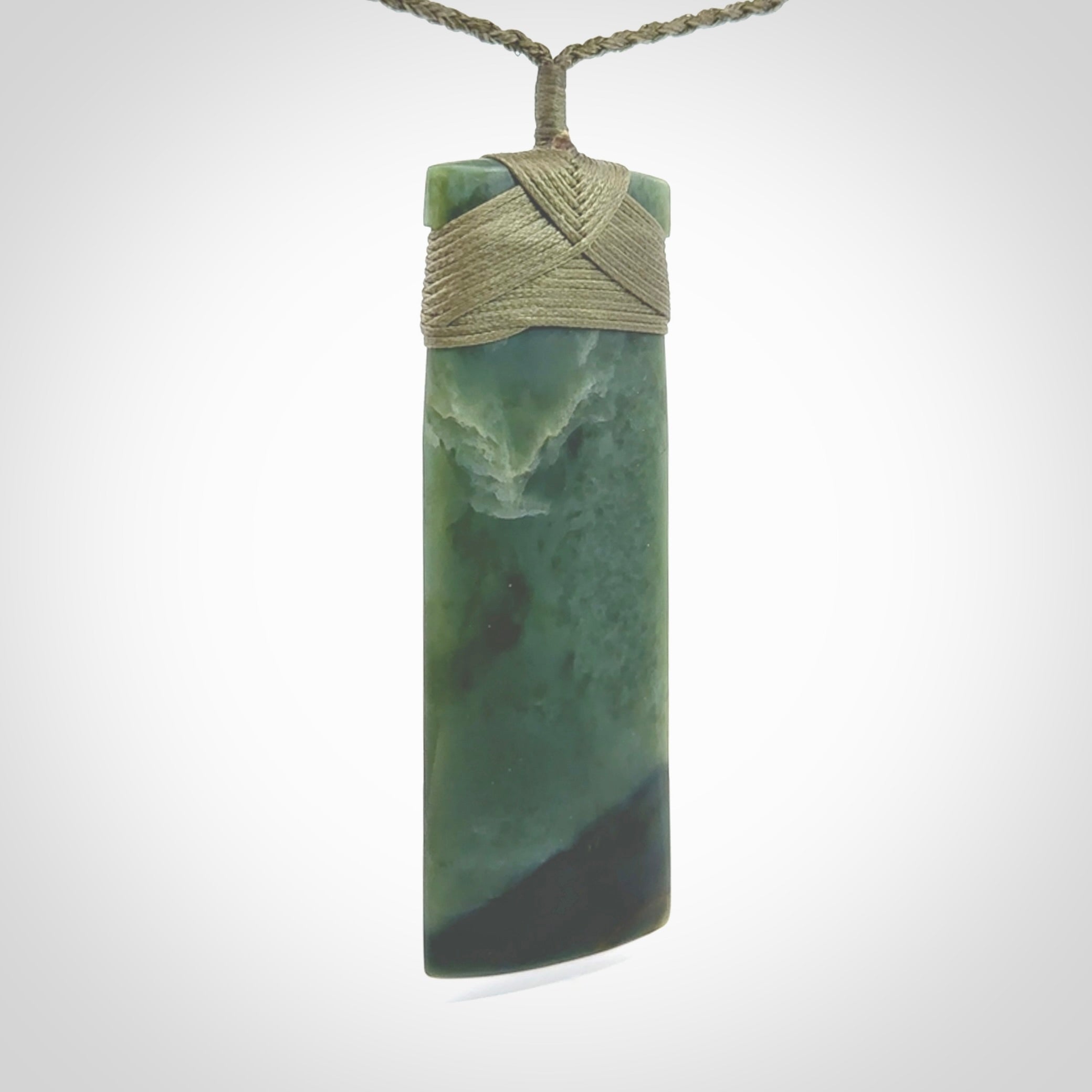 This is a lovely, one-off large, green toki pendant we've made from a gorgeous New Zealand jade. It is finished in a matte sheen and is bound with our plaited cord. These are wonderful pieces that are very attractive and will last a lifetime.