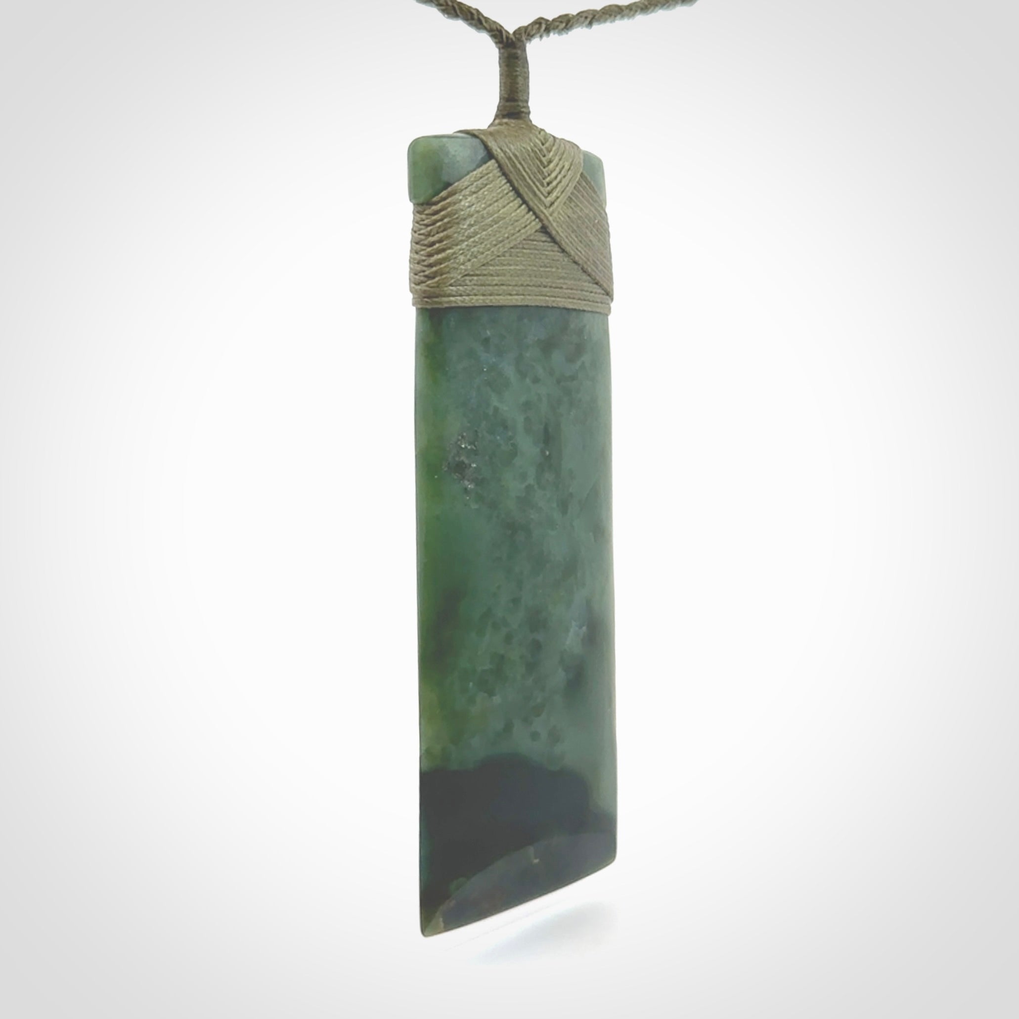 This is a lovely, one-off large, green toki pendant we've made from a gorgeous New Zealand jade. It is finished in a matte sheen and is bound with our plaited cord. These are wonderful pieces that are very attractive and will last a lifetime.