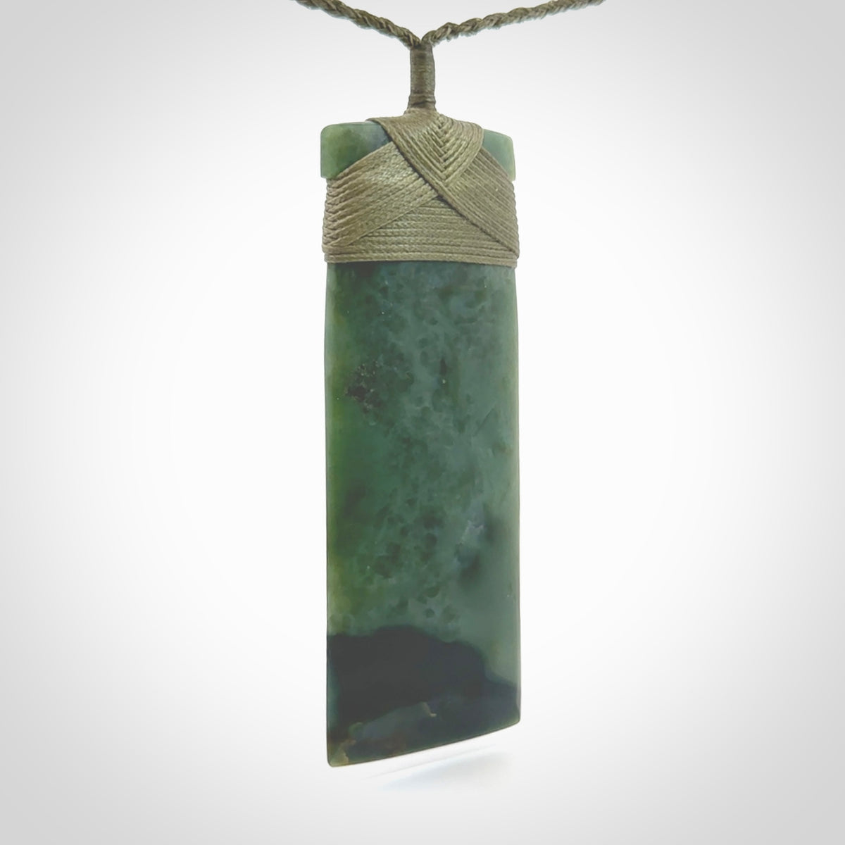 This is a lovely, one-off large, green toki pendant we've made from a gorgeous New Zealand jade. It is finished in a matte sheen and is bound with our plaited cord. These are wonderful pieces that are very attractive and will last a lifetime.