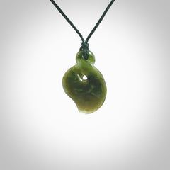 This piece is a fine, delicate drop shaped, single twist pendant. It was carved for us from a lovely semi-translucent green piece of New Zealand jade. It is suspended on an green braided cord that is length adjustable.