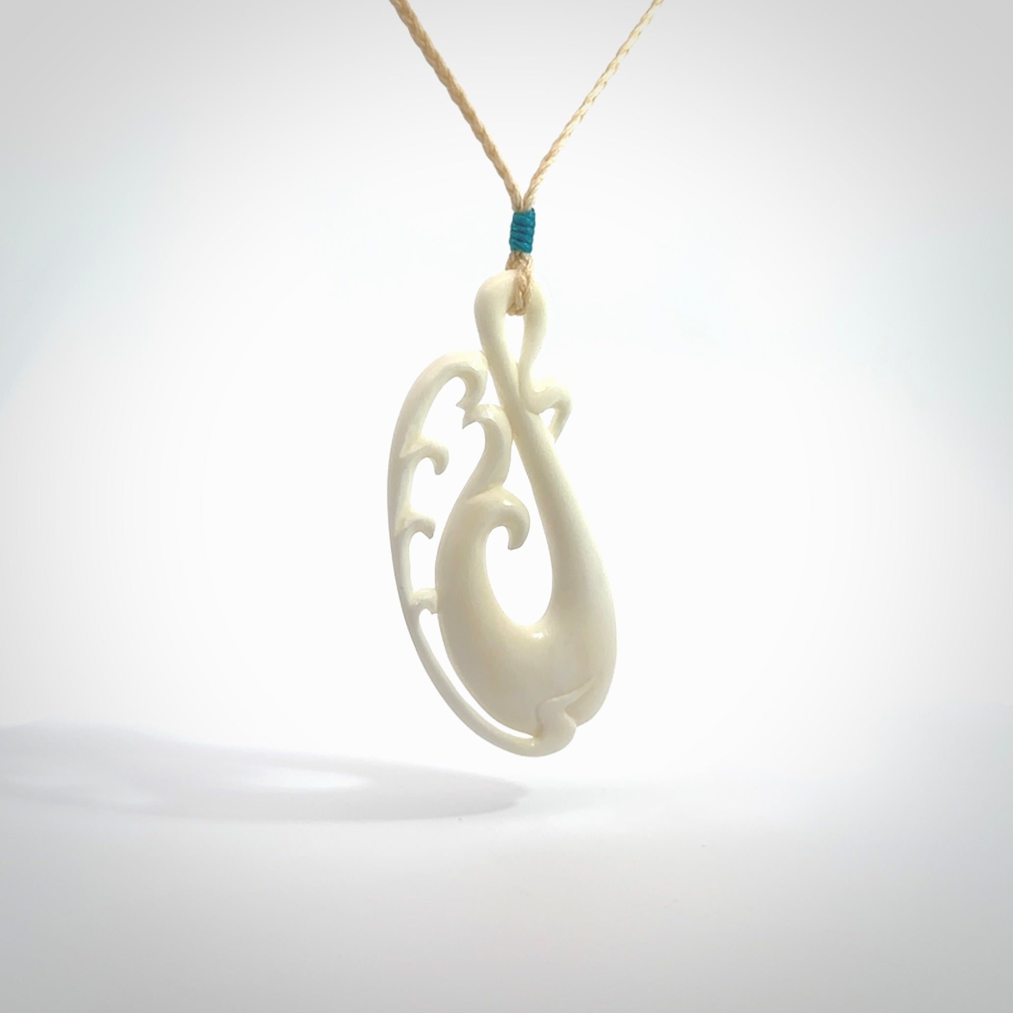 Hand carved bone koru pendant. Carved for NZ Pacific by Yuri Terenyi. Unique bone jewellery for sale online. Provided with adjustable cord and packaged in a woven kete pouch.