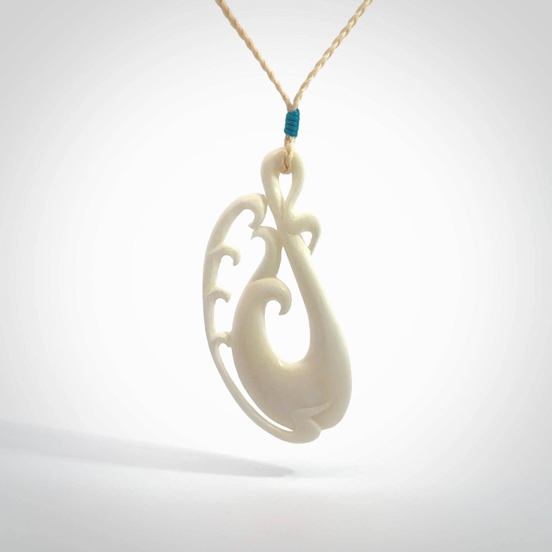 Hand carved bone koru pendant. Carved for NZ Pacific by Yuri Terenyi. Unique bone jewellery for sale online. Provided with adjustable cord and packaged in a woven kete pouch.