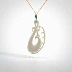 Hand carved bone koru pendant. Carved for NZ Pacific by Yuri Terenyi. Unique bone jewellery for sale online. Provided with adjustable cord and packaged in a woven kete pouch.