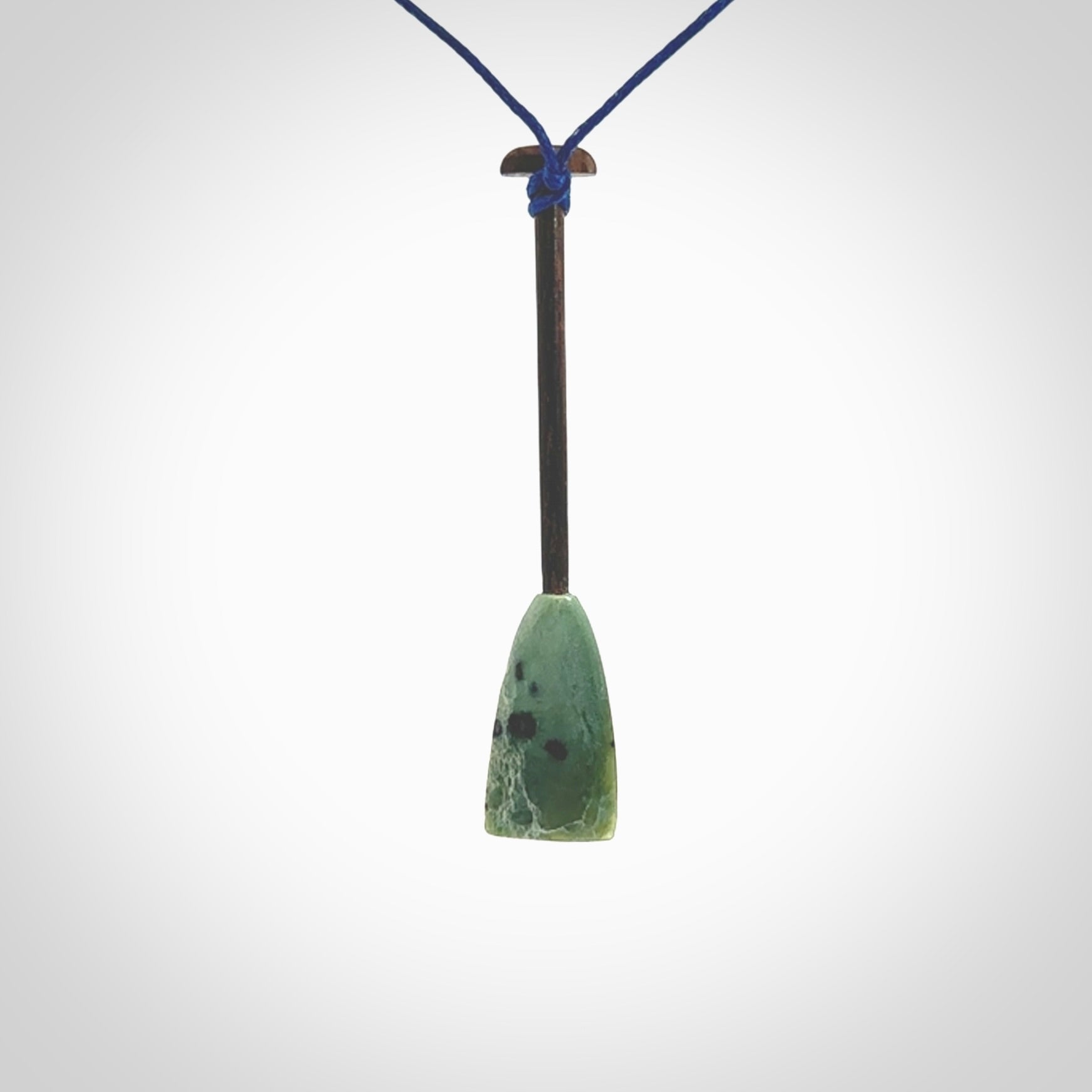 This little pendant is a hand carved dragon boat paddle. We have carved this with a Green Nephrite jade blade and a hardwood handle. It is a necklace that was carved for suffered of breast cancer who are members of the Pink Dragons, a group or cancer fighters who take part in Dragon Boat racing events around the world.