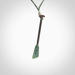 This little pendant is a hand carved dragon boat paddle. We have carved this with a Green Nephrite jade blade and a hardwood handle. It is a necklace that was carved for suffered of breast cancer who are members of the Pink Dragons, a group or cancer fighters who take part in Dragon Boat racing events around the world.