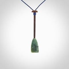 This little pendant is a hand carved dragon boat paddle. We have carved this with a Green Nephrite jade blade and a hardwood handle. It is a necklace that was carved for suffered of breast cancer who are members of the Pink Dragons, a group or cancer fighters who take part in Dragon Boat racing events around the world.