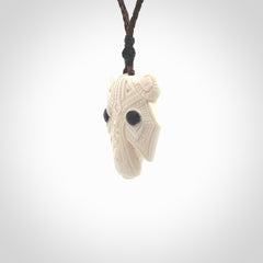 This picture shows a grizzly bear pendant that we designed in bone with buffalo horn inlay eyes. It is a grizzly bear head that is carved in detail. A really attractive and eye-catching piece of handmade jewellery. The cord is hand plaited braid in brown and the length can be adjusted.