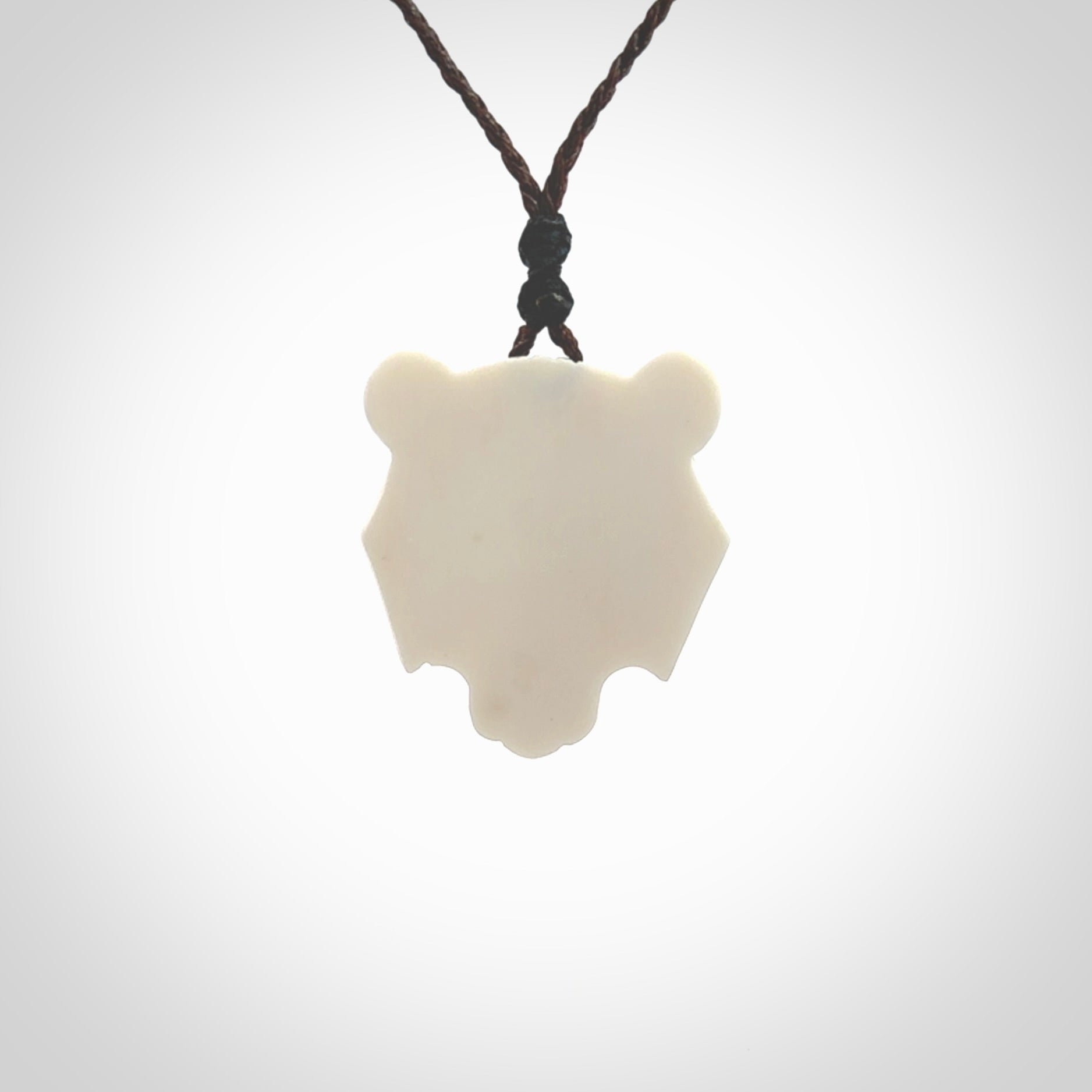 This picture shows a grizzly bear pendant that we designed in bone with buffalo horn inlay eyes. It is a grizzly bear head that is carved in detail. A really attractive and eye-catching piece of handmade jewellery. The cord is hand plaited braid in brown and the length can be adjusted.