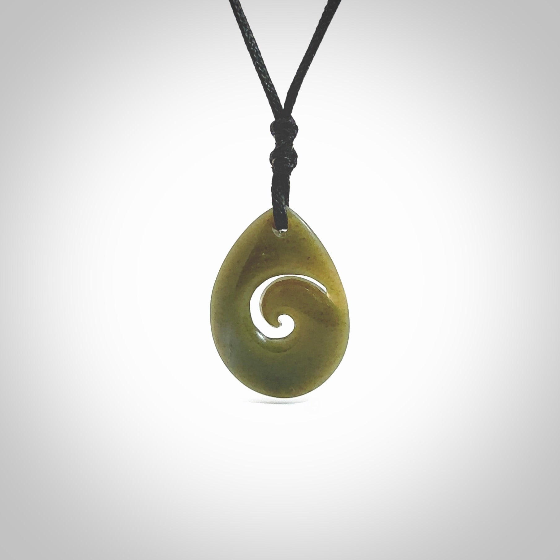 Hand carved New Zealand jade koru drop pendant. Made by NZ Pacific.Hand carved New Zealand jade koru drop pendant. Made by NZ Pacific.