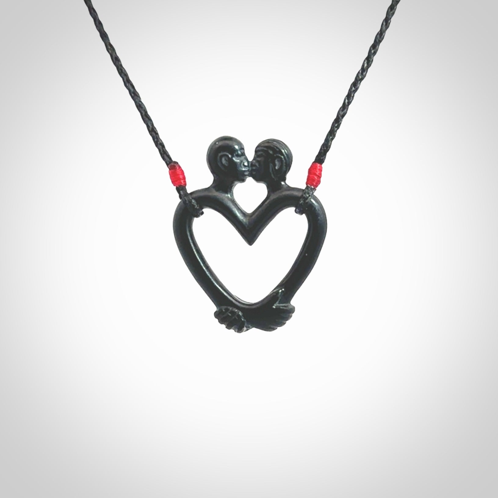 Hand carved Black Jade couples kissing in the shape of a heart pendant. Contemporary design is black jade. Pendants for lovers. Provided with adjustable cord.