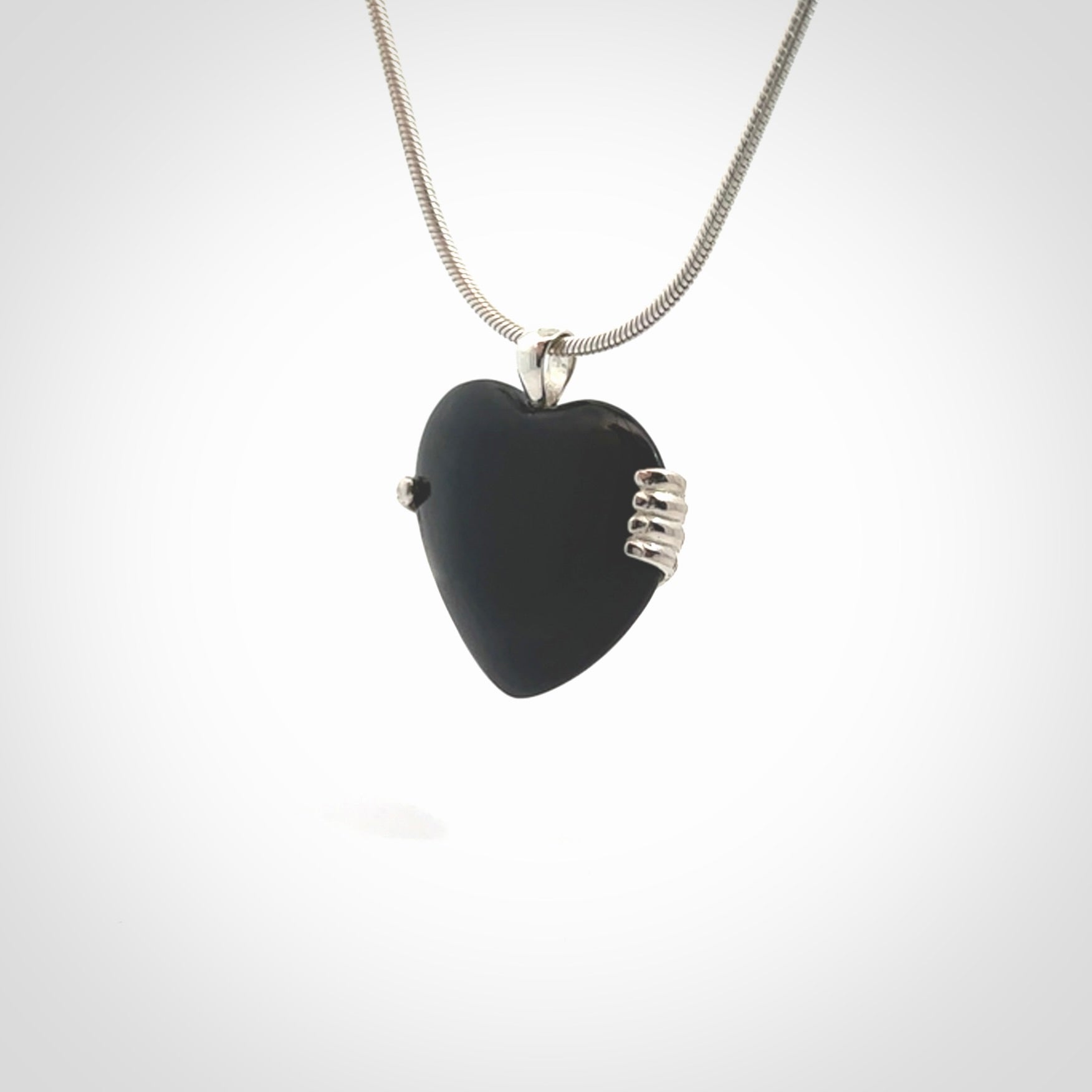 Hand crafted Australian Black jade heart in sterling silver hand necklace. This piece has a sterling silver hand holding a Black Jade heart. This necklace is provided with a sterling silver chain.