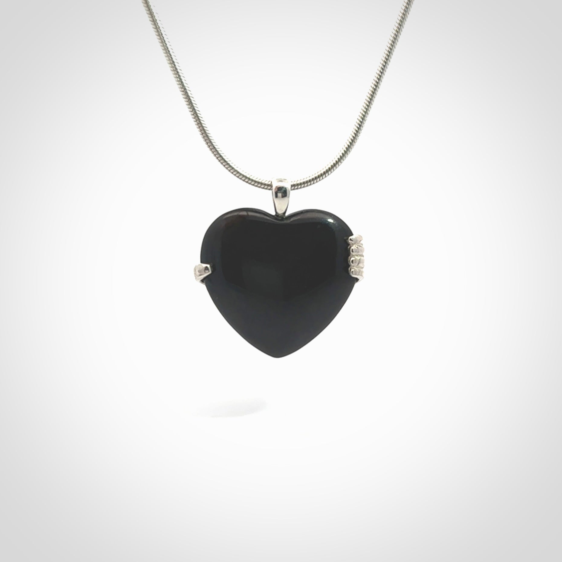 Hand crafted Australian Black jade heart in sterling silver hand necklace. This piece has a sterling silver hand holding a Black Jade heart. This necklace is provided with a sterling silver chain.