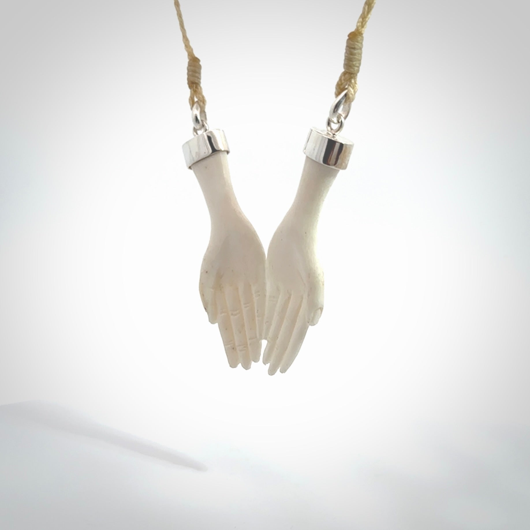 Hand carved large bone double open hands pendant. A stunning work of art. This pendant is hand carved in bone and provided with an adjustable cord. A one off work of art to wear by NZ Pacific.