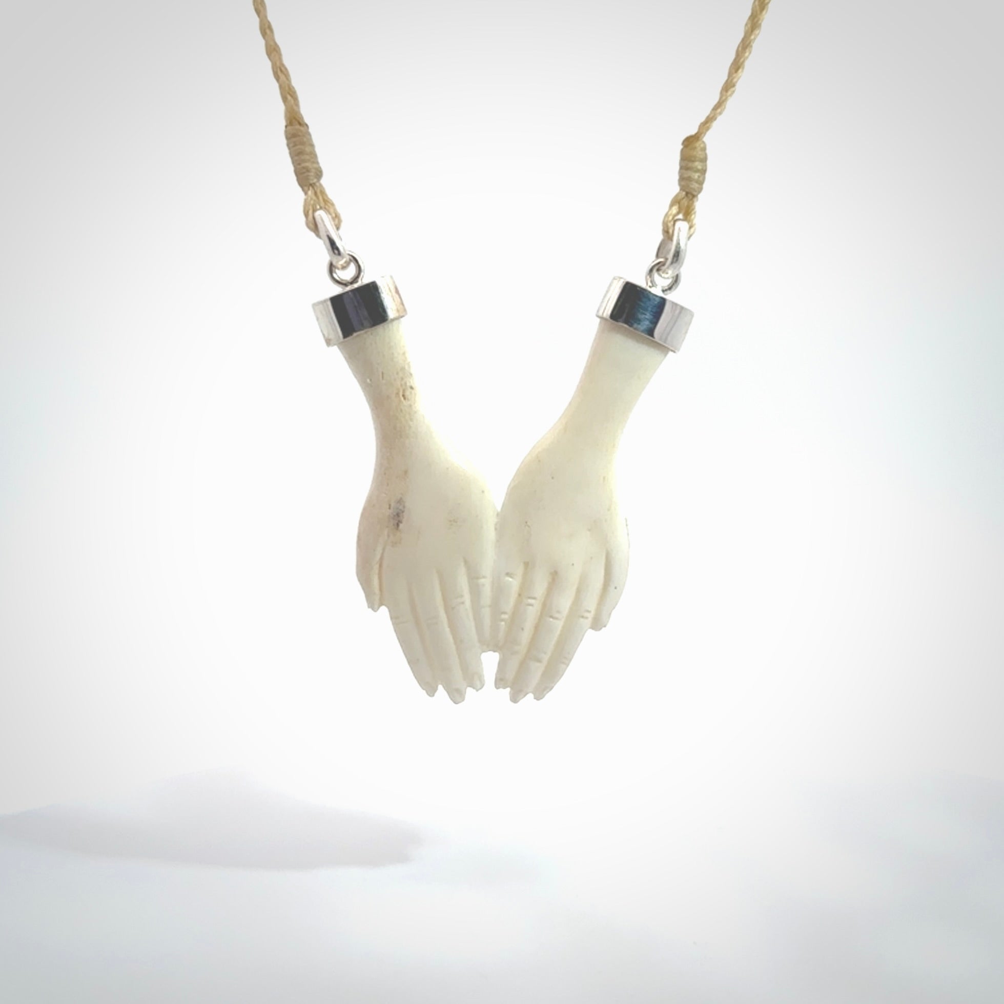 Hand carved large bone double open hands pendant. A stunning work of art. This pendant is hand carved in bone and provided with an adjustable cord. A one off work of art to wear by NZ Pacific.