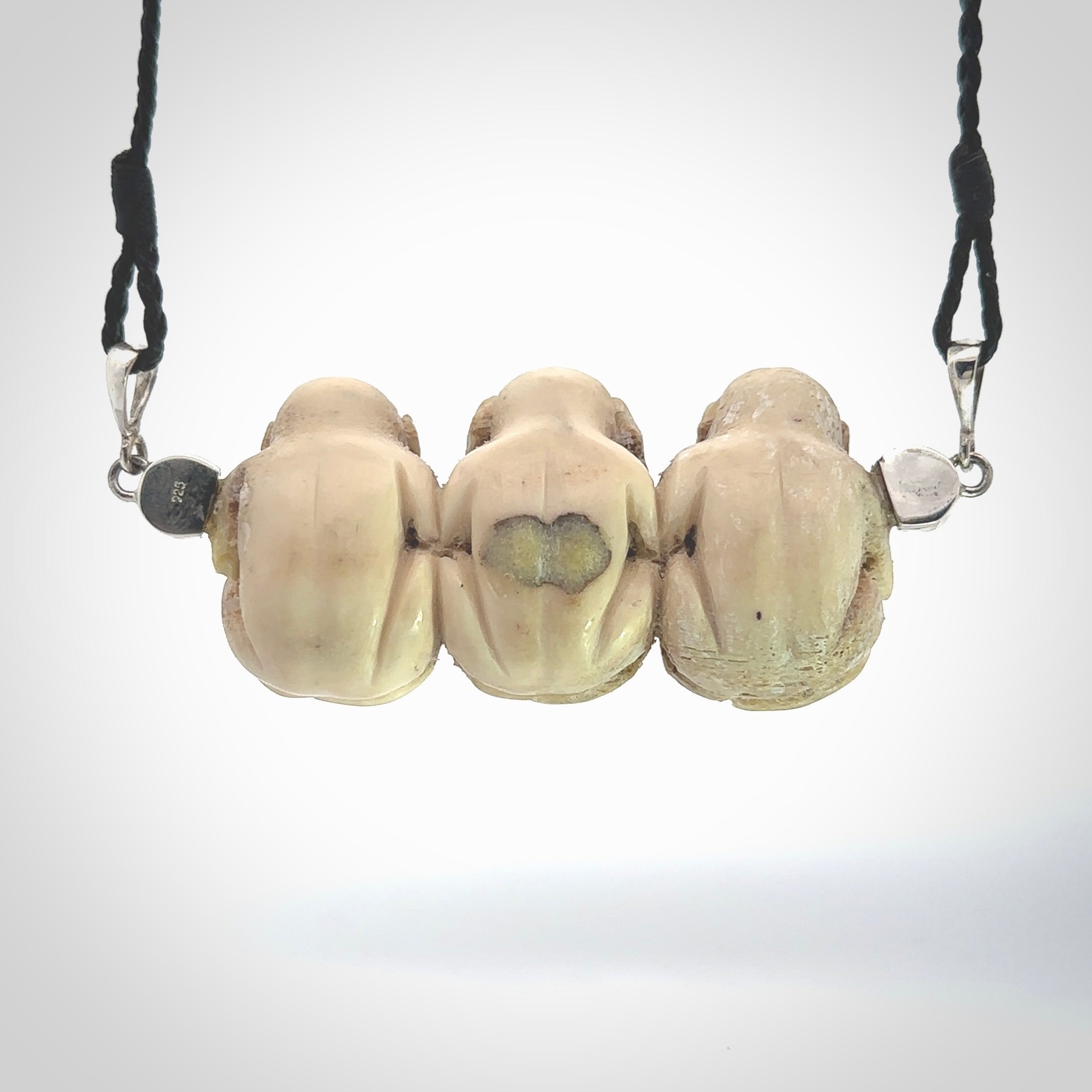 This is a hand carved deer antler three wise monkeys pendant. It is made from deer antler, bone. This is a large sized necklace and is a very unique, one only, pendant that has an adjustable black cord. Hand carved deer antler three wise monkeys necklace for men and women. Hear, Speak, See no evil monkey pendant.