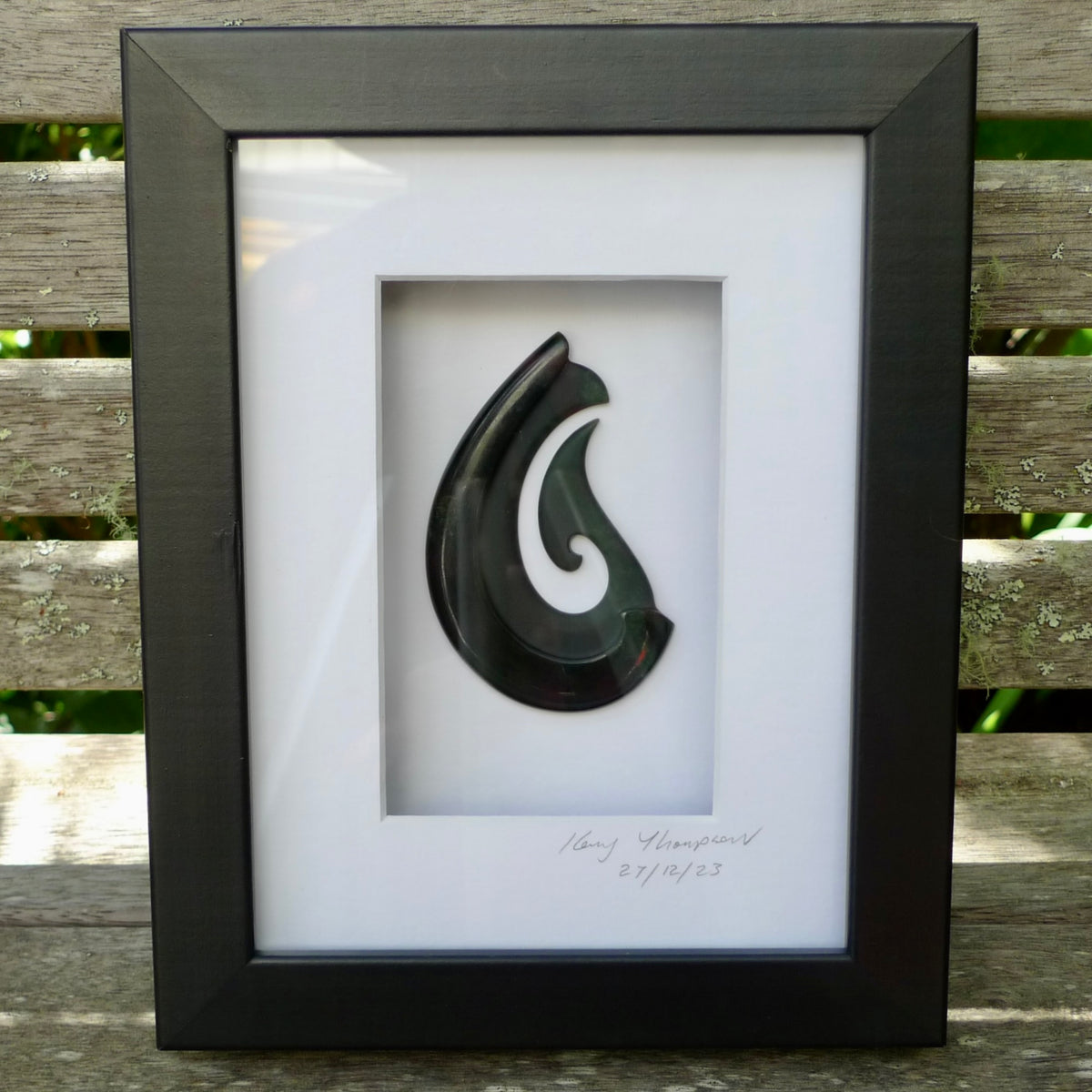 A hand carved large New Zealand Jade Hook necklace that has been framed and signed by artist Kerry Thompson. A large sized hand made Hei Matau necklace by New Zealand artist Kerry Thompson. One off framed work of art to wear. Delivered with Express Courier.