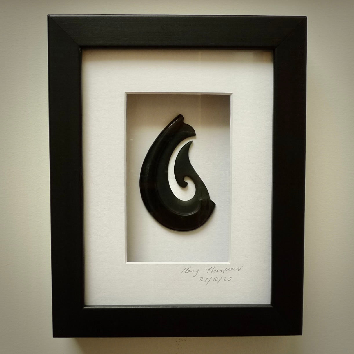 A hand carved large New Zealand Jade Hook necklace that has been framed and signed by artist Kerry Thompson. A large sized hand made Hei Matau necklace by New Zealand artist Kerry Thompson. One off framed work of art to wear. Delivered with Express Courier.