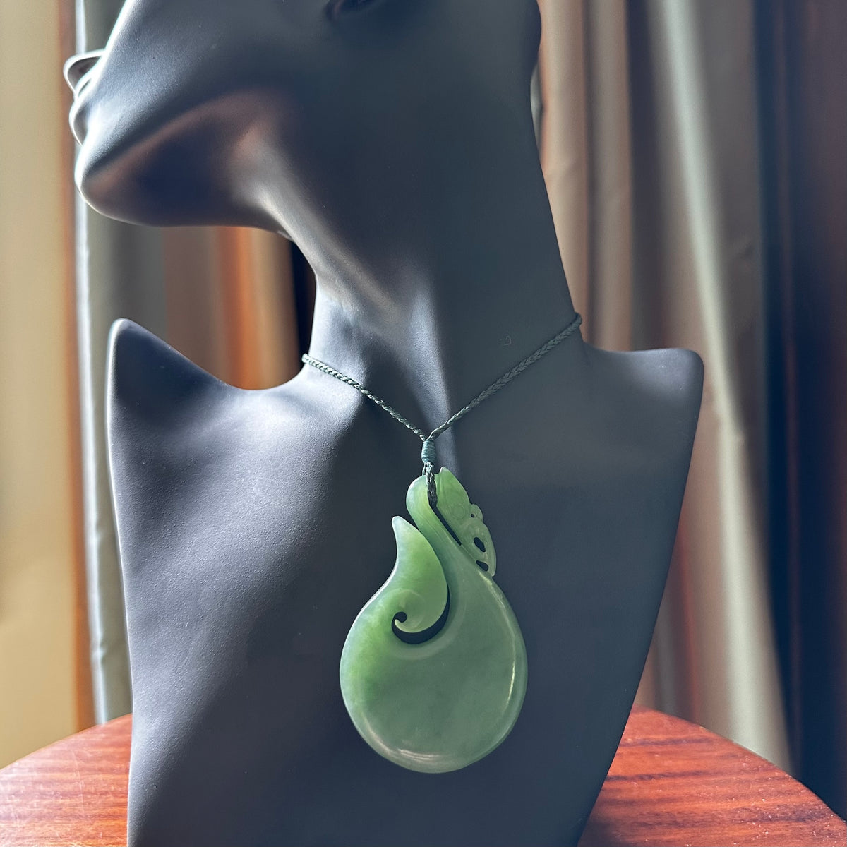 A New Zealand jade manaia necklace carved in lovely New Zealand Inanga jade. The pendant is suspended from a plaited cord. The cord is length adjustable so you can position the pendant where it suits you best. One only Ross Crump Manaia with hook pendant.