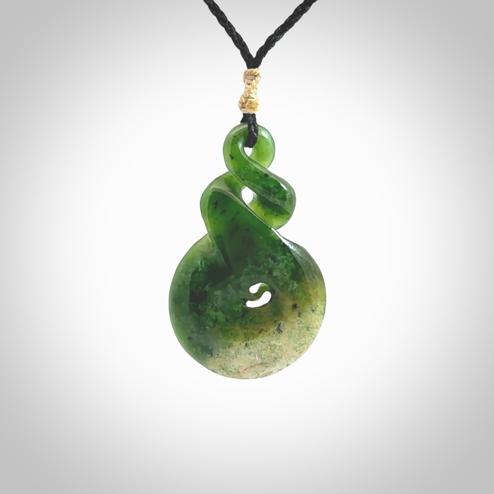 Ross Crump double twist with koru pendant. Hand carved from rare New Zealand Flower jade this is a beautiful pounamu pendant. The cord is length adjustable. It is a delicate and very beautiful greenstone pendant. For sale online by NZ Pacific.