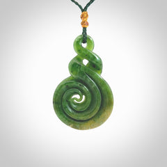 Ross Crump double twist with koru pendant. Hand carved from rare New Zealand Flower jade this is a beautiful pounamu pendant. The cord is length adjustable. It is a delicate and very beautiful greenstone pendant. For sale online by NZ Pacific.