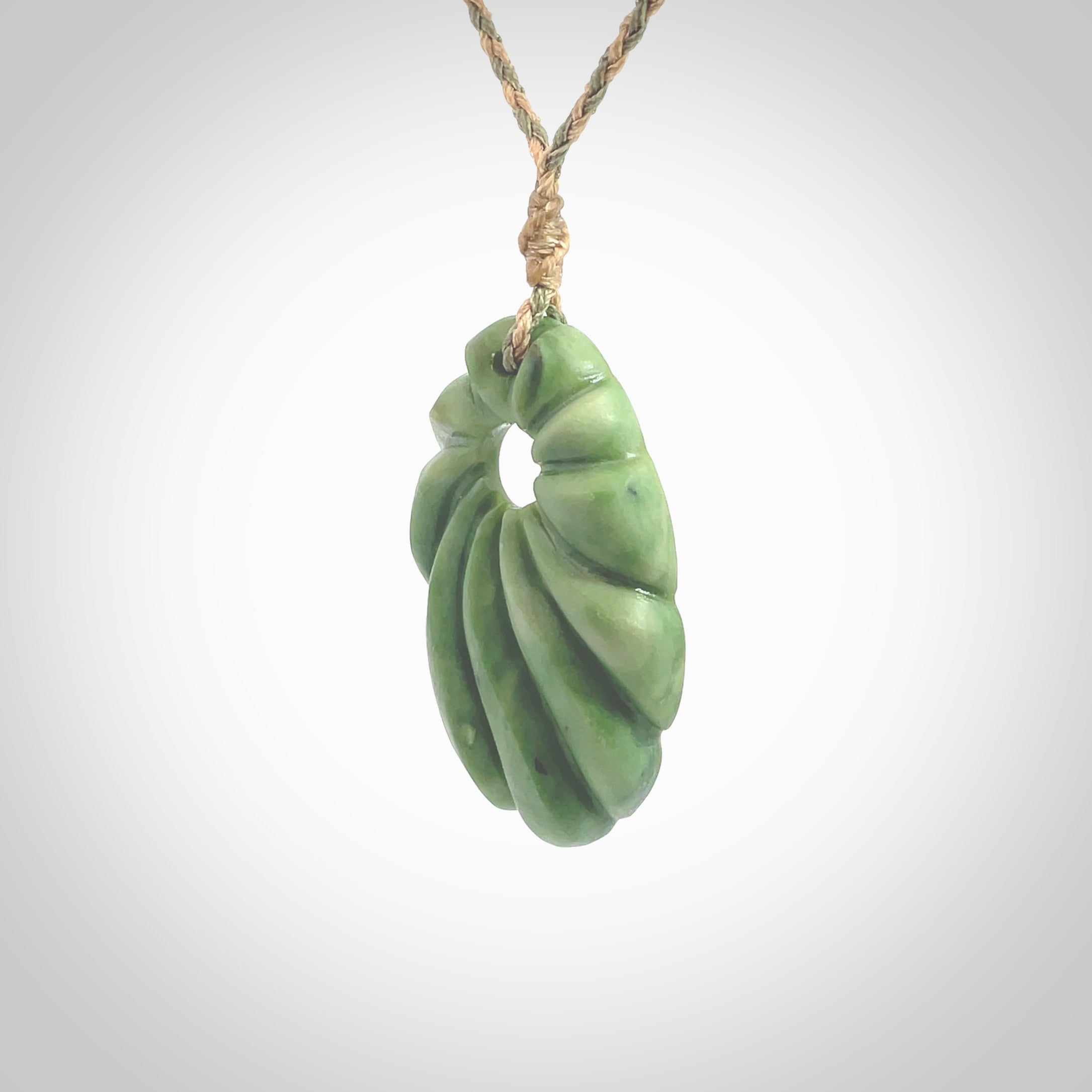 This picture shows a contemporary drop shaped pendant, hand carved from New Zealand flower jade. We will provide this with an adjustable plaited cord. Hand crafted stunning New Zealand Marsden Flower Jade drop pendant by Ana Krakosky.