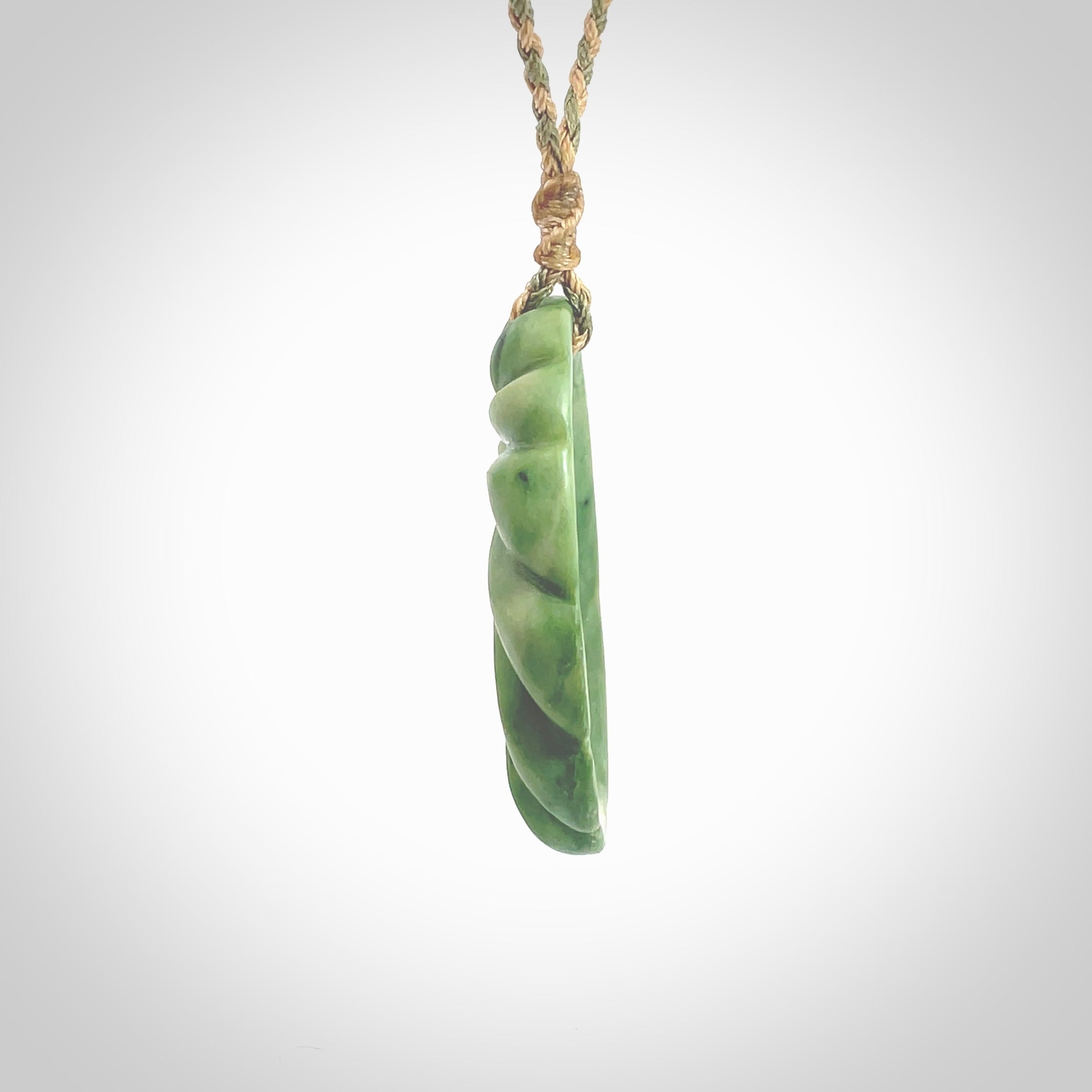 This picture shows a contemporary drop shaped pendant, hand carved from New Zealand flower jade. We will provide this with an adjustable plaited cord. Hand crafted stunning New Zealand Marsden Flower Jade drop pendant by Ana Krakosky.